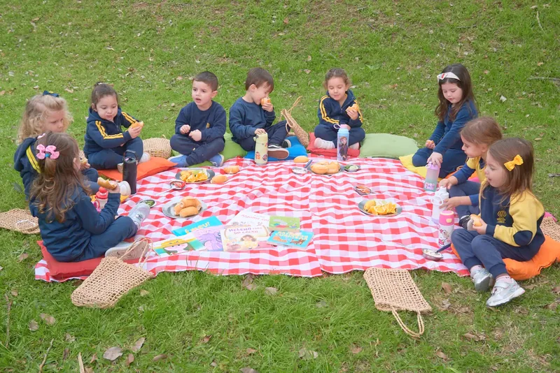 Turma faz lanche coletivo numa toalha xadrez na praça