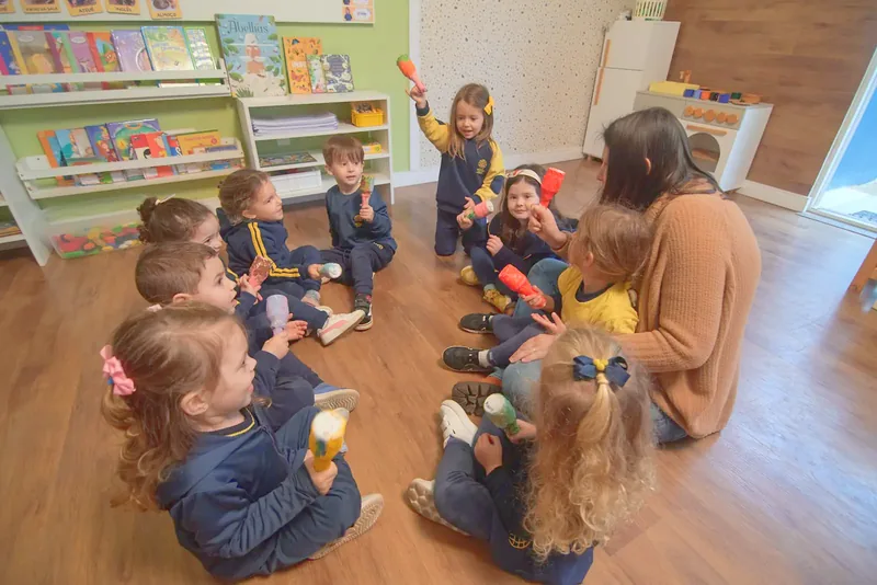 Professora e crianças sentadas em roda na sala