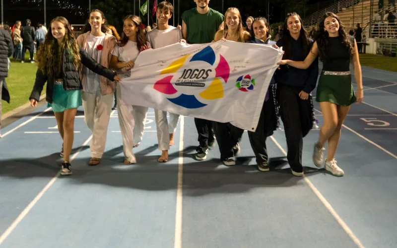 Alunos do Ensino Médio entram na pista com a bandeira dos Jogos do Monteiro